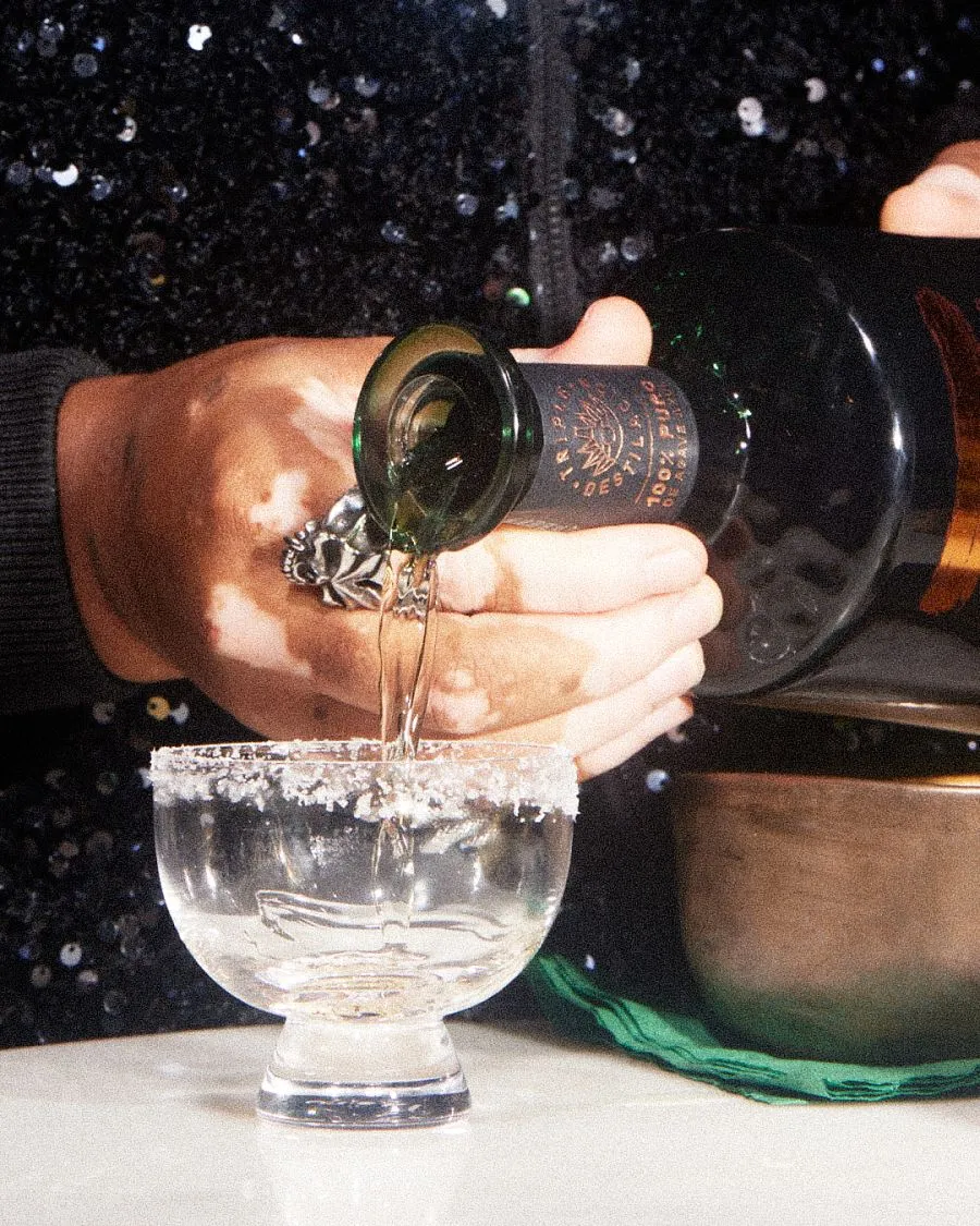 Pouring glass of tequila with salt rim Tres Generaciones